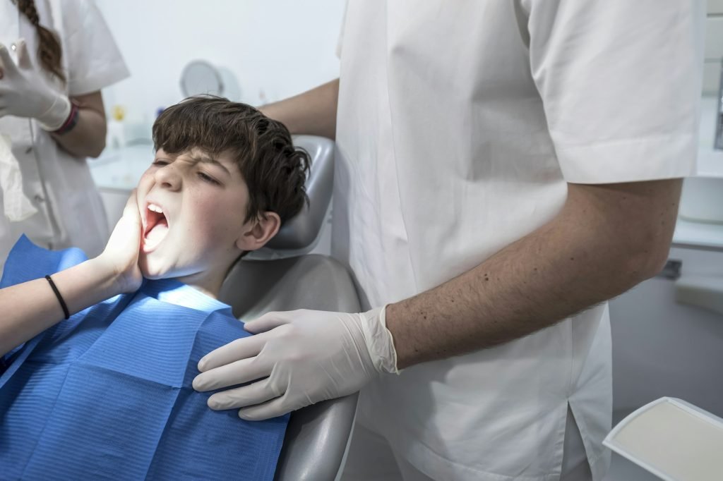 little boy with teeth pain looking sadness on his dentist